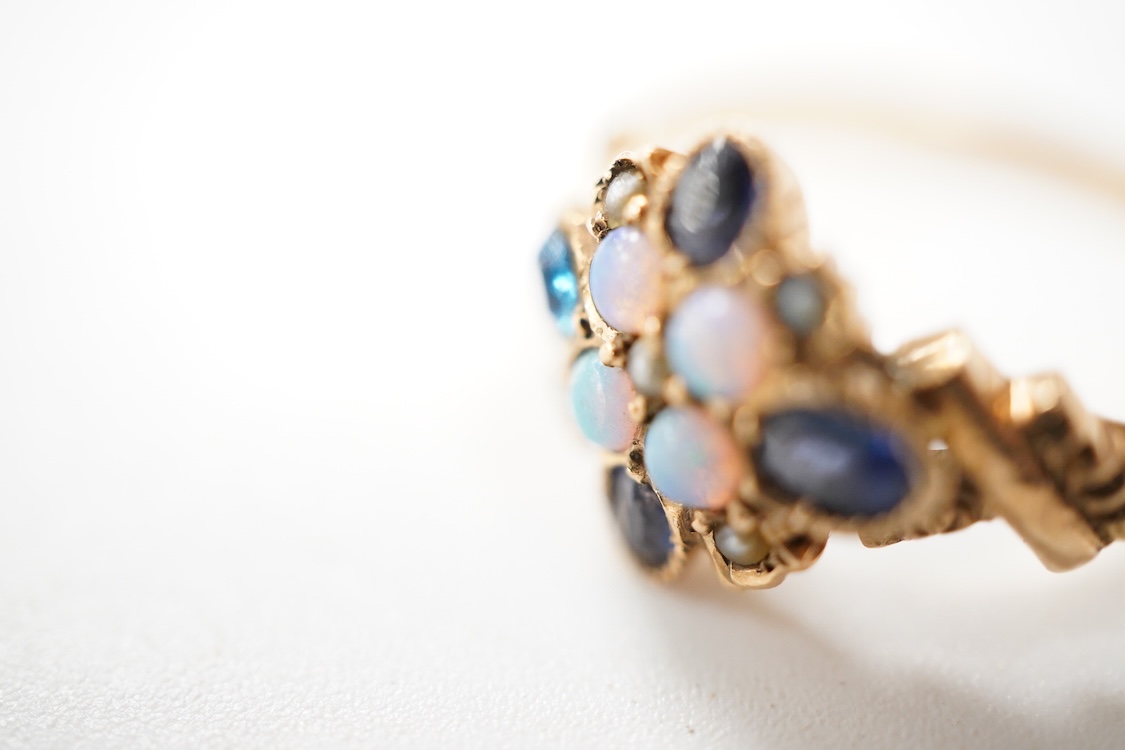A late Victorian yellow metal, sapphire, opal and seed pearl cluster set dress ring, (one stone a paste replacement), size N, gross weight 2.2 grams.